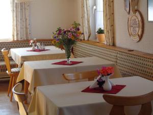 dos mesas en un restaurante con flores. en Jagerhäusl, en Ramsau am Dachstein