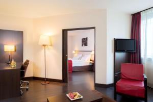 a hotel room with a bed and a mirror at NH Wien City in Vienna