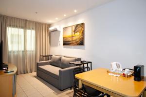 ein Wohnzimmer mit einem Sofa und einem Tisch in der Unterkunft AnnA Suites Ipanema in Rio de Janeiro