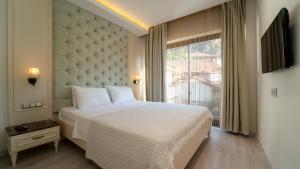 a bedroom with a large bed with a large window at Rooms365 in Fethiye
