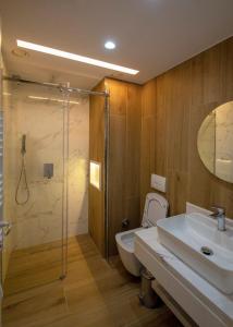 a bathroom with a toilet and a sink and a shower at Dazur Coast Resort in Orikum