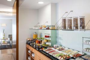 a buffet with various food items on display at NH Frankfurt Messe in Frankfurt