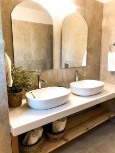 two sinks in a bathroom with two mirrors at Luxury Villa Anemone with private pool in Pastida