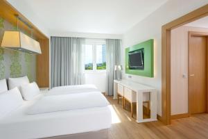 a hotel room with two beds and a desk and a tv at NH Frankfurt Messe in Frankfurt +35 photos