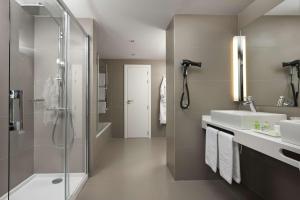 baño con 2 lavabos y ducha de cristal en NH Pamplona Iruña Park, en Pamplona