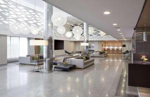 eine Lobby mit Sofas und Stühlen in einem Gebäude in der Unterkunft NH Pamplona Iruña Park in Pamplona