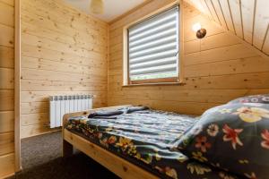 um quarto com uma cama num quarto de madeira em Bieszczadzka Ostoja em Wetlina