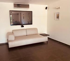 - un canapé blanc dans une chambre avec un miroir dans l'établissement Villa Jungle Beach, à Sainte-Maxime
