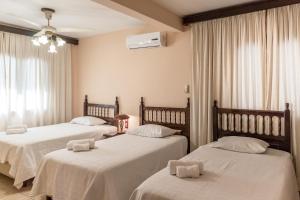 a bedroom with two beds with white sheets at Paramanta Lifestyle Hotel in Asunción