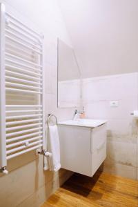 Baño blanco con lavabo y espejo en Casa Cheile Dâmbovicioarei - Cabana 1, en Dîmbovicioara