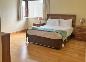 a bedroom with a bed and a large window at Castle Quay Holiday Homes in Kinsale