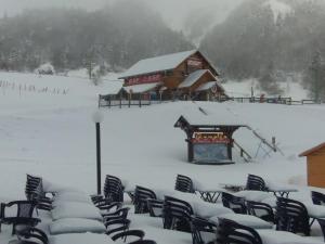 een groep stoelen bedekt met sneeuw voor een gebouw bij Appartement Mont-Dore, 2 pièces, 4 personnes - FR-1-415-8 in Le Mont-Dore