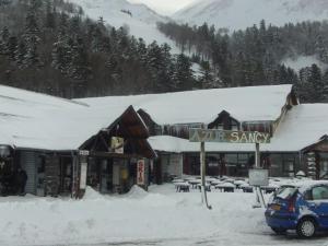 a car parked in front of a snow covered building at F2 au pied des pistes du Mont-Dore avec mezzanine et local à skis - FR-1-415-8 in Le Mont-Dore