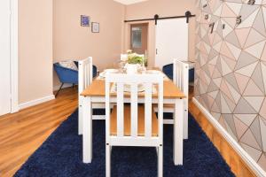 a white dining room table with two white chairs at All Saints House by YourStays in Stoke on Trent