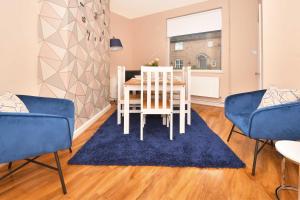 a dining room with a table and chairs and a blue rug at Don't miss out on this wonderful home, great location and 3 bathrooms! in Stoke on Trent