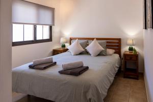 a bedroom with a large bed with two pillows on it at Ideal for family holidays, near beach and golf- Casa James in La Guirra +23 photos