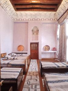 a room with a row of beds in it at Hotel Sohibqiron Boutique in Bukhara