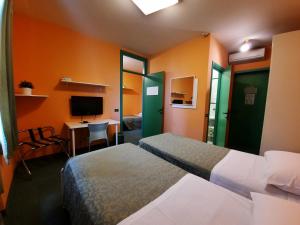 Cette chambre comprend deux lits et un bureau avec un ordinateur. dans l'établissement Ducathotel, à Torrile
