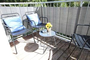 un patio con 2 sillas y una mesa con flores en Spacious Apartment with Balcony, en Wetzlar