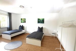 two beds in a room with white walls at Spacious Apartment with Balcony in Wetzlar