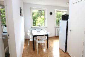 a dining room with a table and chairs and two windows at Spacious Apartment with Balcony in Wetzlar