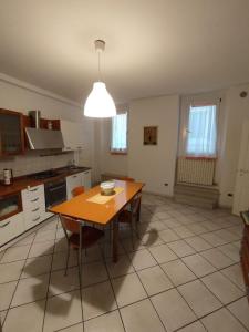 eine Küche mit einem Holztisch und Stühlen in der Unterkunft Appartamento La Fisarmonica Recanati in Recanati