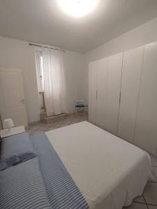 a bedroom with a bed and white cabinets and a window at Appartamento La Fisarmonica Recanati in Recanati