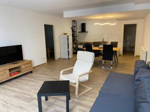 a living room with a couch and a tv and a table at Ferienwohnung Sattelkammer in Bad Rappenau