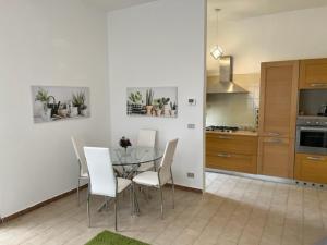 eine Küche mit einem Glastisch und weißen Stühlen in der Unterkunft La casa sui colli bolognesi in Savigno