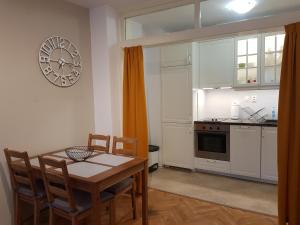 uma cozinha com mesa e cadeiras e um relógio na parede em Apartment Neven em Varna City