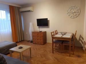 uma sala de estar com um sofá, uma mesa e uma televisão em Apartment Neven em Varna City