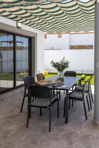 een eettafel en stoelen onder een plafond bij Ideal for family holidays, near beach and golf- Casa James in La Guirra