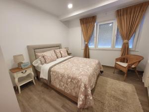 1 dormitorio con 1 cama, 1 silla y ventanas en apartamento_turistico_cedeira en Cedeira