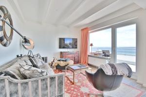 een woonkamer met een bank en uitzicht op de oceaan bij Strandallee 10 Penthouse Seaview in Haffkrug