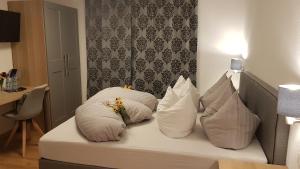 Una cama blanca con almohadas y una mesa. en Pension Burgschroffen, en Fendels