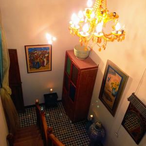 um quarto com uma escada com um lustre em Riad Rchacha em Fez