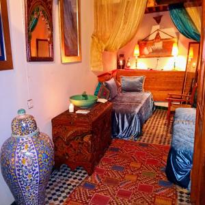 uma sala de estar com um vaso e uma cama em Riad Rchacha em Fez
