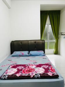a bedroom with a bed with a floral bedspread at SA @ Cameron Emerald Avenue in Brinchang