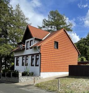 uma casa com um laranja e branco em Ferienwohnungen Marianne Lau em Wernigerode