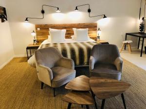 um quarto com uma cama e 2 cadeiras em Zewwelatreppler - La Grange aux Petits Oignons - Chambre Cigogne em Sélestat