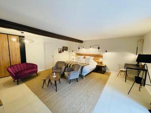 une chambre d'hôtel avec un lit et un fauteuil rouge dans l'établissement Zewwelatreppler - La Grange aux Petits Oignons - Chambre Cigogne, à Sélestat