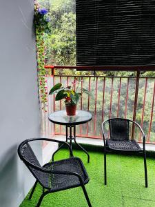 a table and two chairs on a balcony with a plant at SA @ Cameron Emerald Avenue in Brinchang