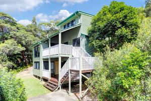 a green house on a hill with trees at My Island Home in Point Lookout