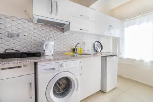 a white kitchen with a washing machine in it at Apartments Near to City Center and Beach in Marmaris