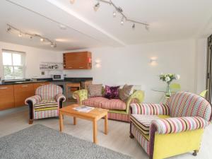 a living room with two couches and a table at The Lodge at Cross Cottage in Wrexham