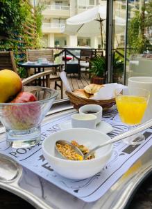uma mesa com uma tigela de comida e uma taça de fruta em Blu Inn em Punta del Este