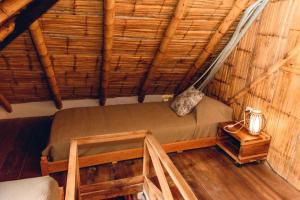 a room with a bed in a straw hut at Tiki Limbo in Montañita