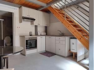 a kitchen with white cabinets and a wooden staircase at St. Lazaros Studios 2 in Larnaca