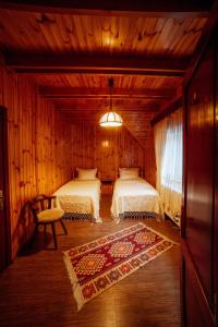 sypialnia z 2 łóżkami w drewnianym domku w obiekcie Casa Cheile Dâmbovicioarei - Cabana 2 w mieście Dâmbovicioara