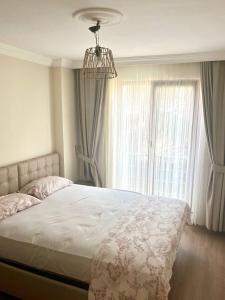 a bedroom with a bed with a chandelier and a window at Halic Apart Hotel in Yalova
